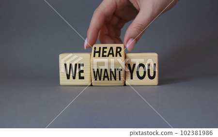 We hear and want You symbol. Businessman Hand turns cubes and changes word We want you to We hear you. Beautiful grey background. Business and We hear and want You concept. Copy space 102381986