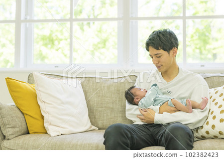 Dad holding a baby Dad holding a baby 102382423