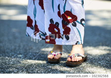 Feet wearing clogs of a young woman wearing a yukata Feet wearing clogs of a young woman wearing a yukata 102382568