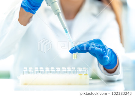 pipetting of chemical samples during research in a biochemical scientific laboratory 102383243