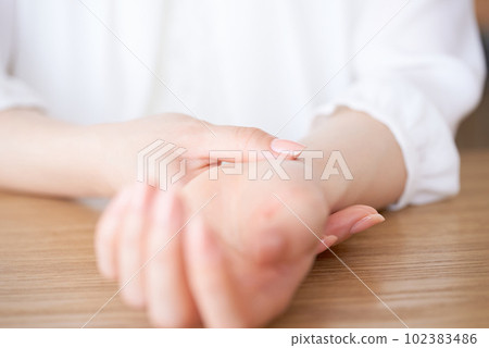 Woman's hand measuring pulse Woman's hand measuring pulse 102383486