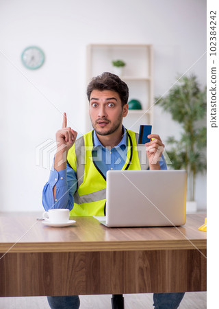Young male architect holding credit card Young male architect holding credit card 102384242