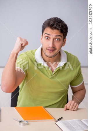 Young male student sitting in the classroom 102385769