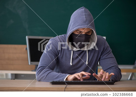 Young male hacker sitting in the classroom 102386668