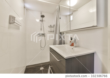 a bathroom with white walls and wood flooring in the shower area, while it appears to be used as a sink 102386766