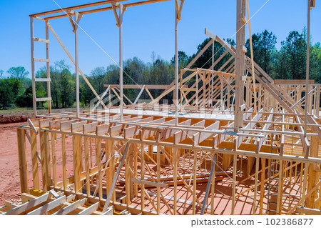 Construction frame house of wooden beam stick frame on new build home Construction frame house of wooden beam stick frame on new build home 102386877