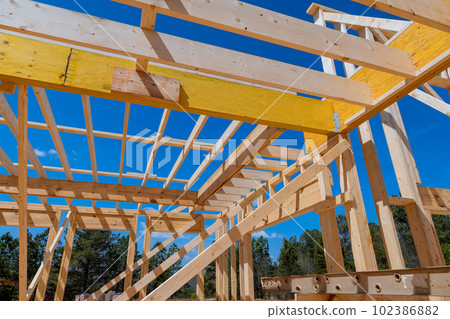 In order to build new house there will be construction frame house made from wooden beams stick framework In order to build new house there will be construction frame house made from wooden beams stick framework 102386882