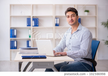 Young male employee working in the office Young male employee working in the office 102386998