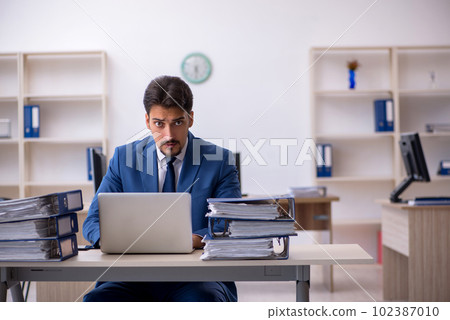 Young businessman employee unhappy with excessive work in the of 102387010