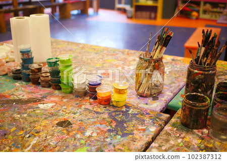 Paints and paint brushes in an artists studio. Paints and paint brushes in an artists studio. 102387312