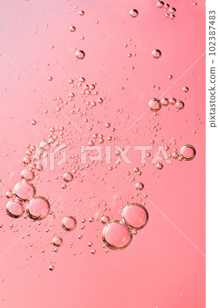 Facial serum oil surface with water bubbles. cosmetic liquid pink 102387483