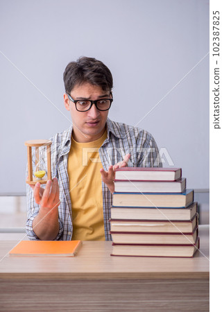 Young male student in time management concept Young male student in time management concept 102387825