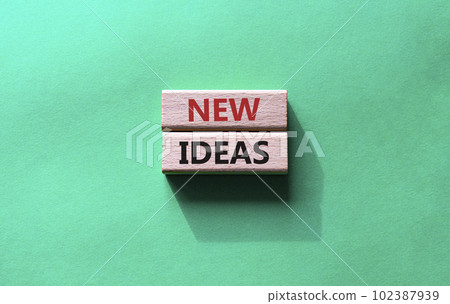 New ideas symbol. Concept word New ideas on wooden blocks. Beautiful green background. Business and New ideas concept. Copy space 102387939