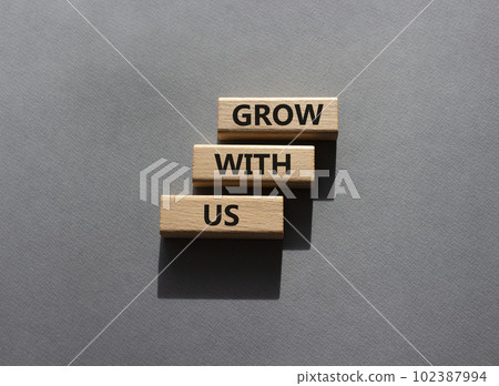 Grow with us symbol. Wooden blocks with words Grow with us. Beautiful grey background. Business and Grow with us concept. Copy space. Grow with us symbol. Wooden blocks with words Grow with us. Beautiful grey background. Business and Grow with us concept. Copy space. 102387994