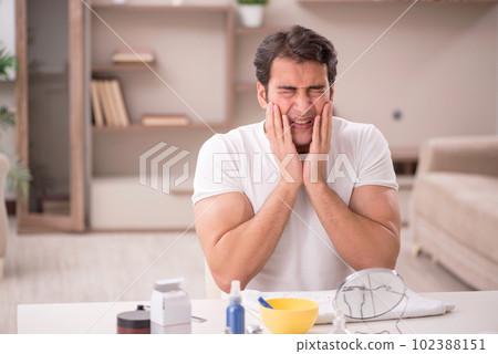Young man shaving face at home 102388151