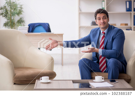 Young male employee sitting in the office Young male employee sitting in the office 102388187