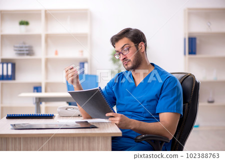 Young male doctor working in the clinic 102388763