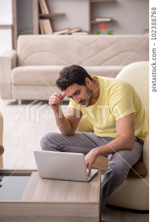 Young man working from home during pandemic Young man working from home during pandemic 102388768