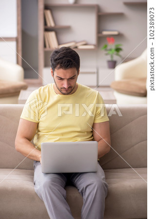 Young man working from home during pandemic 102389073