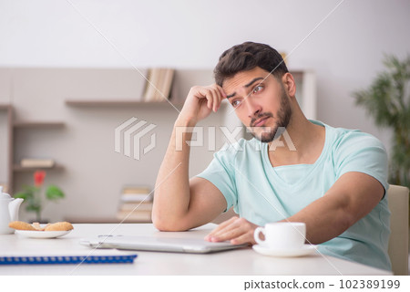 Young male freelancer working from home 102389199