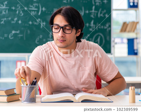 Young male student in the classroom 102389599