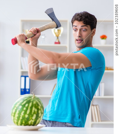 Man eating watermelon at home 102389608