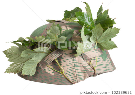 German Nazi Army steel helmet camouflaged with cover and tree leaves. World War II period 1933-1945. German Nazi Army steel helmet camouflaged with cover and tree leaves. World War II period 1933-1945. 102389651