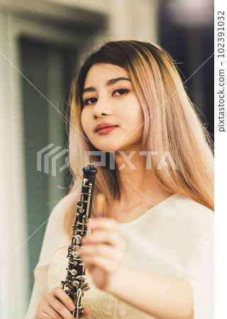 Portrait of Young Female Musician Playing Clarinet. Rehearsal before performing on stage. 102391032