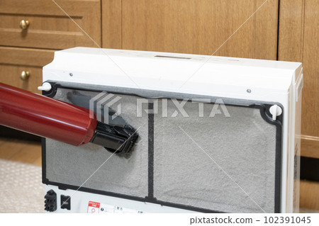 House cleaning man's hand cleaning the filter of the gas fan heater House cleaning man's hand cleaning the filter of the gas fan heater 102391045