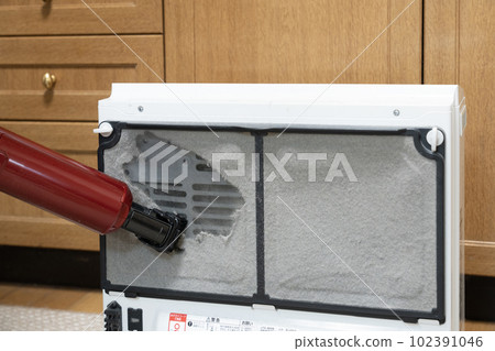 House cleaning man's hand cleaning the filter of the gas fan heater House cleaning man's hand cleaning the filter of the gas fan heater 102391046