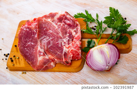 Sliced raw pork chop with parsley and onion 102391987