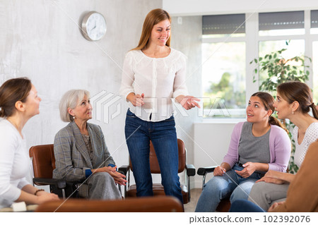 Woman tells an interesting story. Female students listening carefully in classroom 102392076