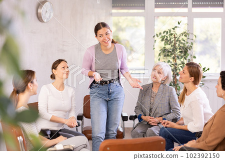 Cheerful young girl talking to female colleagues during break 102392150