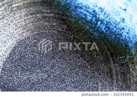 黑色背景上具有淺藍色斑點和白色筆劃的陶瓷圓形表面紋理 102393041