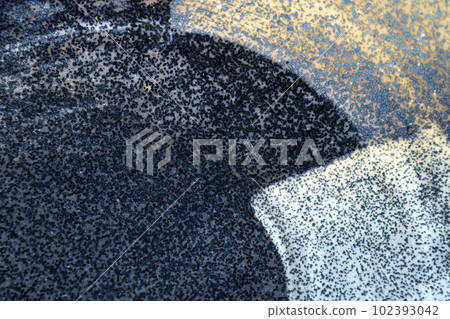 黑藍色背景上具有亮白色和金色圓形刷子圖案的陶瓷表面紋理 102393042