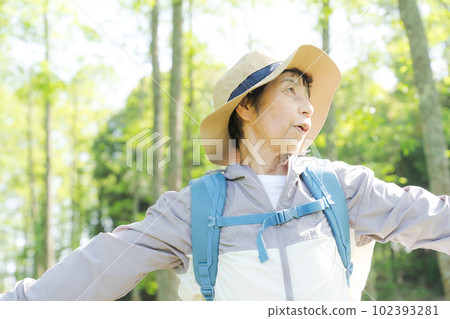 一位高級女性在新綠色中徒步旅行的照片 102393281