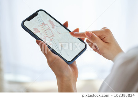 Hand of a woman looking at a map on a smartphone 102393824