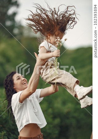 Family in a summer park. Mother in a white t-shirt. Cute little girl 102393894