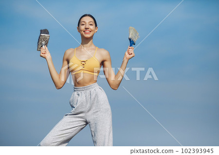 Beautiful girl standing on a sky background. Woman in a yellow top. Lady with tools in her hands Beautiful girl standing on a sky background. Woman in a yellow top. Lady with tools in her hands 102393945
