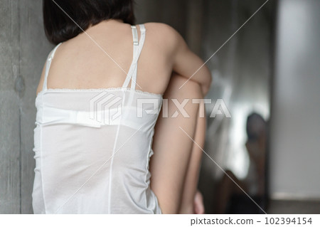 Woman sitting in underwear in front of a mirror Woman sitting in underwear in front of a mirror 102394154