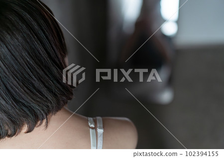 Woman sitting in underwear in front of a mirror Woman sitting in underwear in front of a mirror 102394155