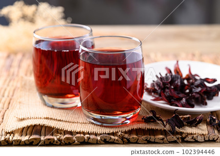 Roselle tea in glass with dried roselle, Herbal drink for reduction in blood pressure Roselle tea in glass with dried roselle, Herbal drink for reduction in blood pressure 102394446