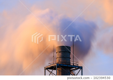 White smoke blowing up from the chimney dyed in the setting sun White smoke blowing up from the chimney dyed in the setting sun 102394530