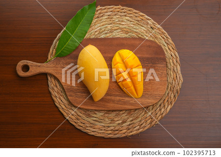 Ripe mango on wood,Ripe Mango Slice on wooden cutting board Ripe mango on wood,Ripe Mango Slice on wooden cutting board 102395713
