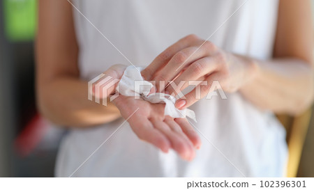 Woman cleaning hands using antiseptic wipes, hand hygiene 102396301