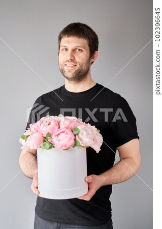 Round box with Pink Angel Cheeks peonies in a men hand. Beautiful peony flower for catalog or online store. Floral shop concept . Beautiful fresh cut bouquet. Flowers delivery Round box with Pink Angel Cheeks peonies in a men hand. Beautiful peony flower for catalog or online store. Floral shop concept . Beautiful fresh cut bouquet. Flowers delivery 102396645