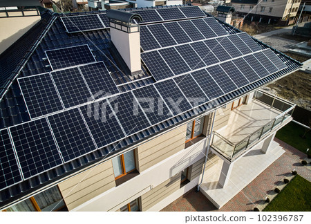 Residential house with solar modules for generating electricity through photovoltaic effect. Home with solar power system on roof. Concept of alternative energy and power sustainable resources. Residential house with solar modules for generating electricity through photovoltaic effect. Home with solar power system on roof. Concept of alternative energy and power sustainable resources. 102396787