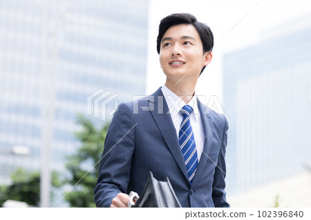 一個年輕的商人在戶外散步 102396840