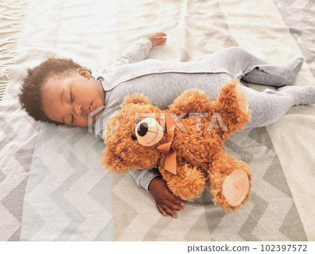 Sleeping, teddy bear and nap with baby in bedroom for tired, development and innocence. Dreaming, relax and comfortable with african infant and toy at home for morning, resting and bedtime 102397572