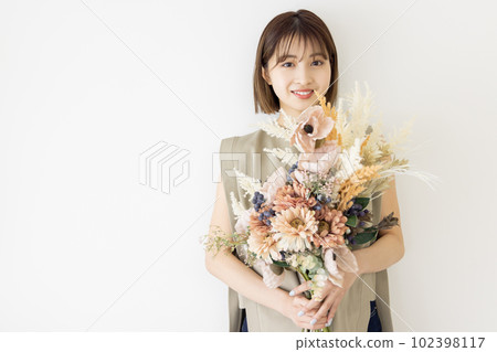 Woman with a bouquet of dried flowers Woman with a bouquet of dried flowers 102398117